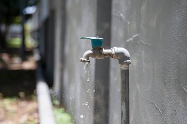 Evin dışındaki eski musluk damlıyor.