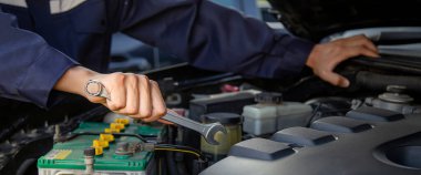 Tamirci garajdaki arabanın motoru üzerinde çalışıyor, araba tamir servisi..