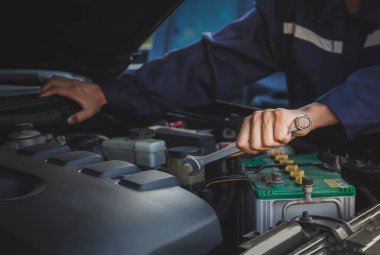 Tamirci garajdaki arabanın motoru üzerinde çalışıyor, araba tamir servisi..