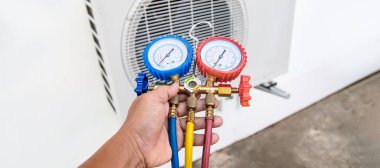 technician checks the operation of the air conditioner.