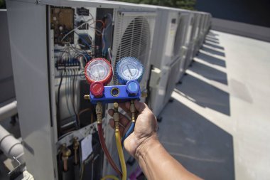 The engineer checks the operation of the air conditioner, checks the pressure, fills and refills the air conditioning refrigerant.