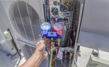 The engineer checks the operation of the air conditioner, checks the pressure, fills and refills the air conditioning refrigerant.