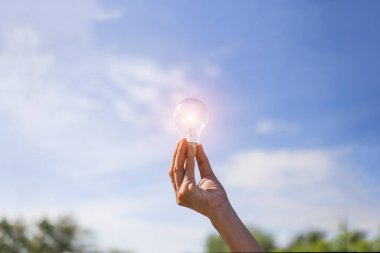 El ele tutuşmak ampul, doğal enerji ve dünya konseptini sevmek.