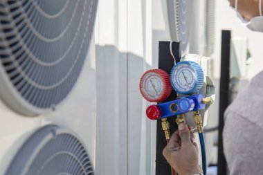 The engineer checks the operation of the air conditioner, checks the pressure, fills and refills the air conditioning refrigerant.