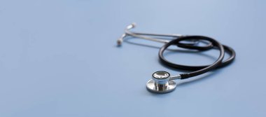 Black stethoscope on blue background, health care concept