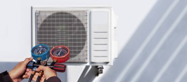Klima, havalandırma servis teknisyeni soğutucu ve soğutucu eklemek için göstergeler kullanıyor..
