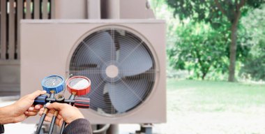 Klima, havalandırma servis teknisyeni soğutucu ve soğutucu eklemek için göstergeler kullanıyor..