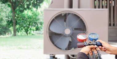 Klima, havalandırma servis teknisyeni soğutucu ve soğutucu eklemek için göstergeler kullanıyor..