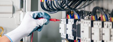 Elektrik mühendisleri elektrik tesisatlarını ve elektrik kablolarını çoklu metre ile ölçerek test ederler..