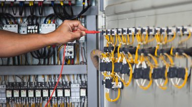 Elektrik mühendisi elektrik kontrol dolabının işleyişini kontrol ediyor. bakım kavramı