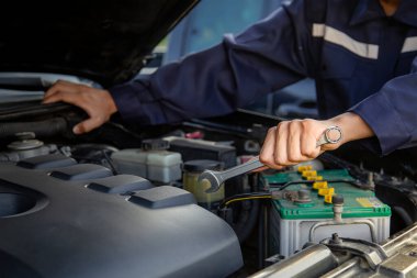 Tamirci garajdaki arabanın motoru üzerinde çalışıyor, araba tamir servisi..