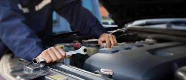 Tamirci garajdaki arabanın motoru üzerinde çalışıyor, araba tamir servisi..