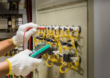 An electrical engineer is inspecting the operation of an electrical control cabinet. maintenance concept