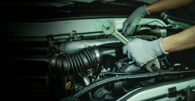 Tamirci garajdaki arabanın motoru üzerinde çalışıyor, araba tamir servisi..