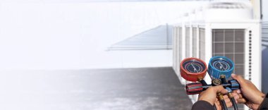 Klima, havalandırma servis teknisyeni soğutucu ve soğutucu eklemek için göstergeler kullanıyor..