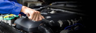 Tamirci garajdaki arabanın motoru üzerinde çalışıyor, araba tamir servisi..