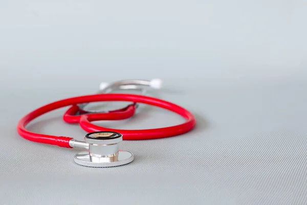 stock image red stethoscope on gray background ,health care concept.