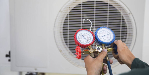 Кондиционирование воздуха, технический специалист по обслуживанию кондиционеров, использующий датчики для проверки хладагента и добавления хладагента.