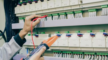 Elektrik mühendisi, kabine kontrolündeki voltaj ve elektrik hattının akımını ölçen bir testçi..