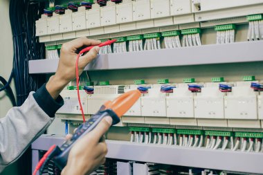 Elektrik mühendisi, kabine kontrolündeki voltaj ve elektrik hattının akımını ölçen bir testçi..