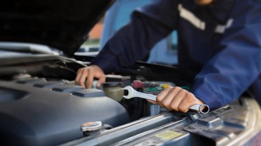 Tamirci garajdaki arabanın motoru üzerinde çalışıyor, araba tamir servisi..