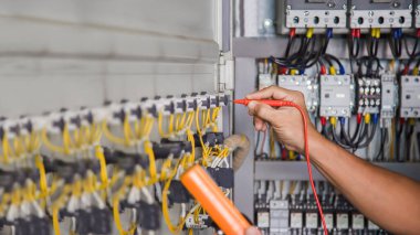 Electrical engineer checking the operation of electrical control cabinet, maintenance concept.