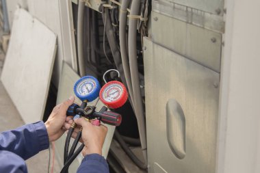 Klima teknisyeni havalandırmayı kontrol ediyor.