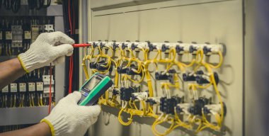 Elektrik mühendisleri elektrik tesisatlarını ve elektrik kablolarını çoklu metre ile ölçerek test ederler..