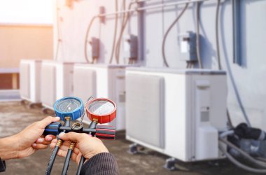 Klima, havalandırma servis teknisyeni soğutucu ve soğutucu eklemek için göstergeler kullanıyor..