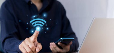 Wi-Fi ikonu olan bir iş adamı dizüstü bilgisayar kullanıyor. İş iletişimi sosyal ağ kavramı.