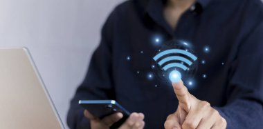 Wi-Fi ikonu olan bir iş adamı dizüstü bilgisayar kullanıyor. İş iletişimi sosyal ağ kavramı.