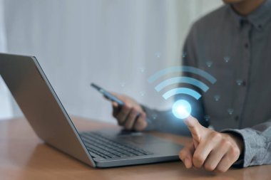 Wi-Fi ikonu olan bir iş adamı dizüstü bilgisayar kullanıyor. İş iletişimi sosyal ağ kavramı.