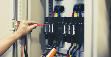Elektrik mühendisi ekipman operasyonel elektrik kontrolünü denetliyor.