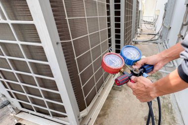 Technician checking the operation of the air conditioner. clipart