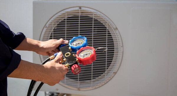 Technician checking the operation of the air conditioner.