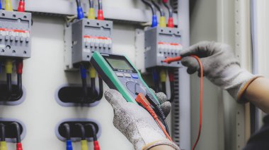 Elektrik mühendisi elektrik kontrol ekipmanlarını denetliyor.