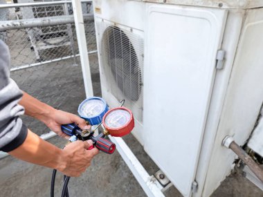 Klima teknisyeni havalandırmayı kontrol ediyor.