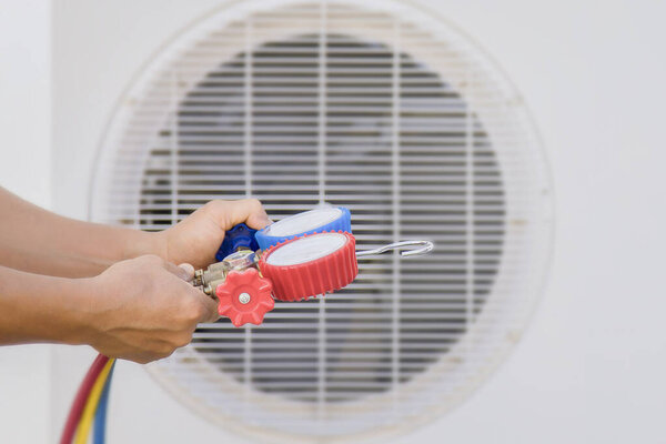 Air conditioner technician checking air conditioner operation