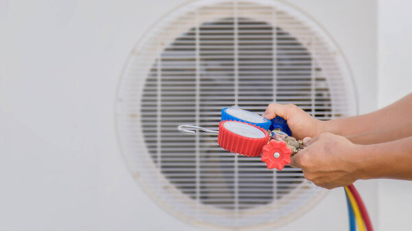 Air conditioner technician checking air conditioner operation