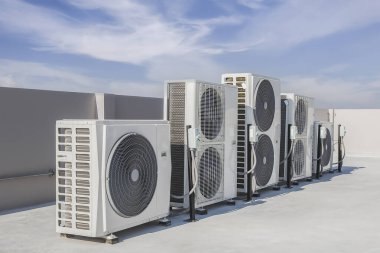 Air conditioning (HVAC) on the roof of an industrial building with blue sky.