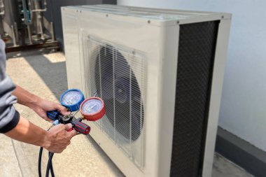 technician checks the operation of the air conditioner.
