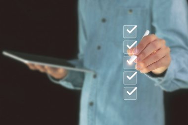 Kontrol listesi konsepti. İşadamı onay kutularını işaretliyor.