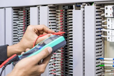 Elektrik mühendisleri elektrik tesisatlarını ve elektrik kablolarını çoklu metre ile ölçerek test ederler..