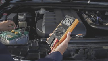 Otomatik tamirci tamir atölyesindeki pilleri kontrol ediyor.