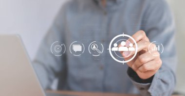 İş pazarlama konsepti, iş adamı müşteri hedef grubu için oklu dart tahtası simgesi tutuyor.