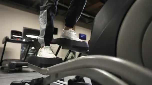 ジムで楕円歩行機械で運動する女性 ウォーキングマシンでフィットネスガールトレーニング — ストック動画
