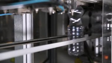  Plastik şişe üretimi. PET şişesi ya da plastik şişe üfleme makinesi. Boru hattından geçen plastik konteynırlar.