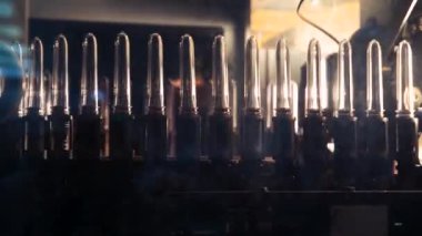  Plastik şişe üretimi. PET şişesi ya da plastik şişe üfleme makinesi. Boru hattından geçen plastik konteynırlar.
