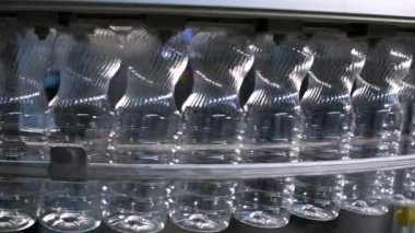  Plastik şişe üretimi. PET şişesi ya da plastik şişe üfleme makinesi. Boru hattından geçen plastik konteynırlar.