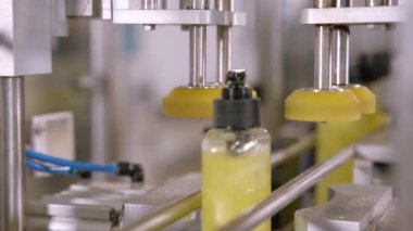 Otomatik kimyasal ürünler doluyor. Sıvı deterjan dolu plastik PET şişeleri taşıyıcı bant boyunca hareket ediyor. Otomatik şişe doldurma makinesi.